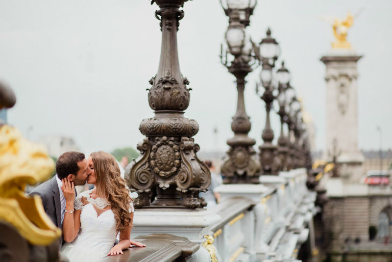 Un couple rÃ©cemment mariÃ© s'embrasse sur le pont Alexandre III Ã  Paris
